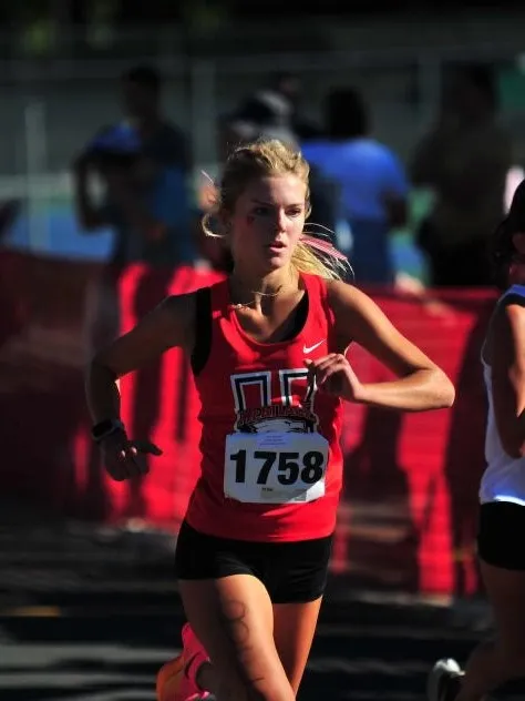 A runner competing in a race for their school.